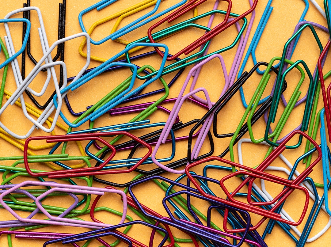 Clipes de papel coloridos sobre fundo laranja