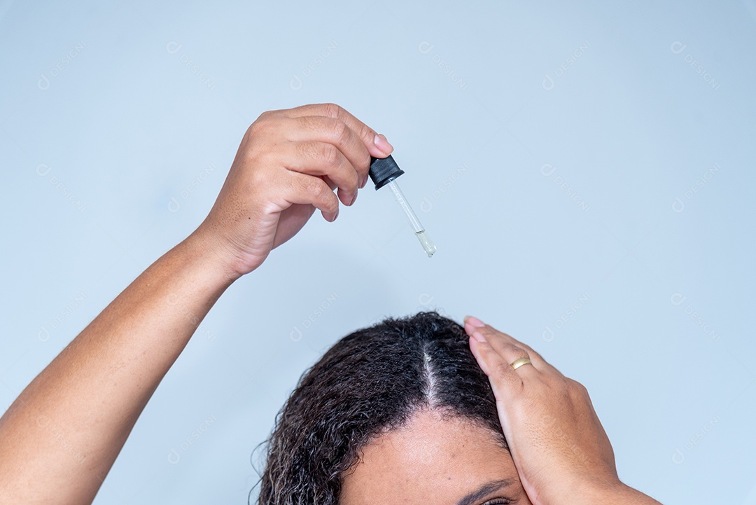 Mulher aplicando cosmético no cabelo