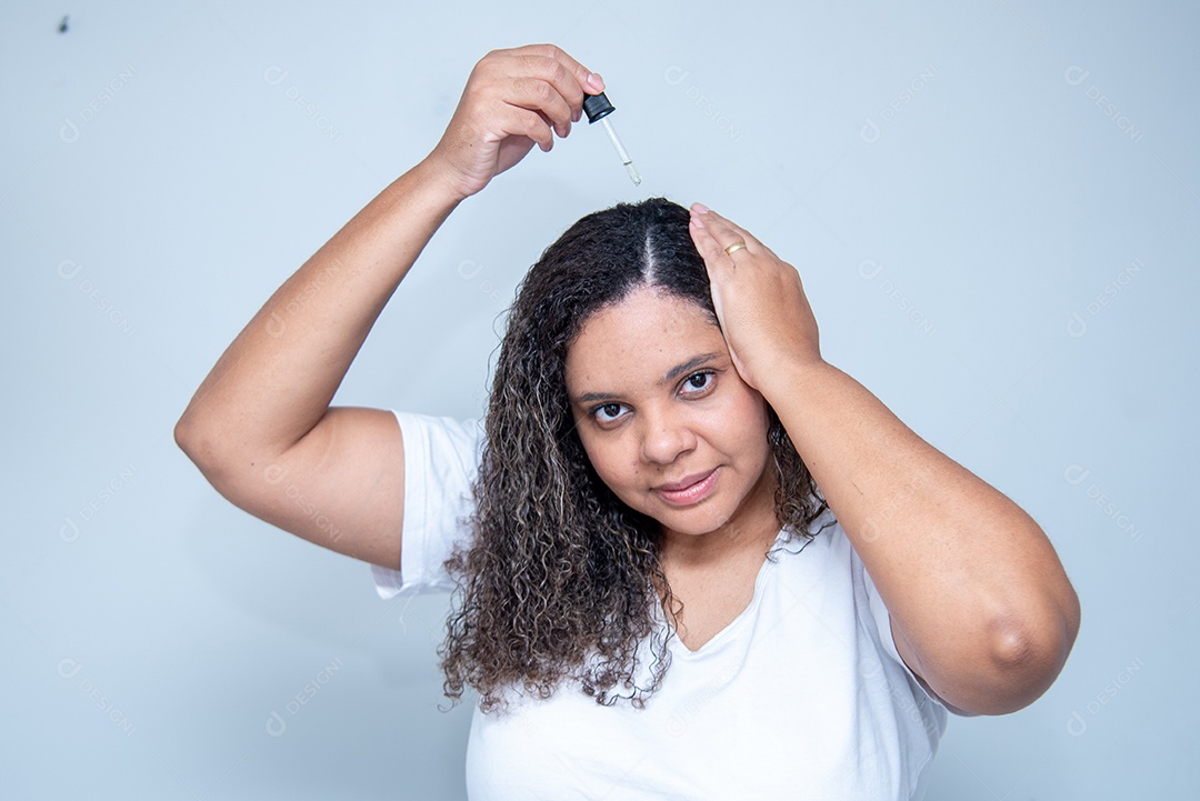 Mulher aplicando cosmético em seu couro cabeludo