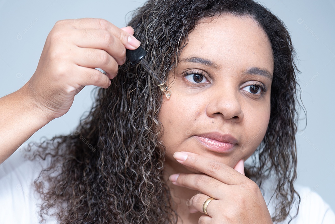 Mulher aplicando serum facial