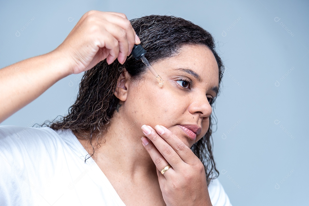 Mulher aplicando serum facial