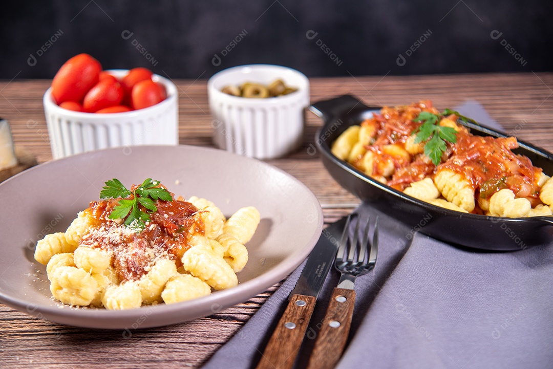 Mesa posta com nhoque ao molho e queijo ralado