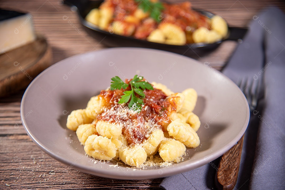 Prato com nhoque e molho de queijo ralado