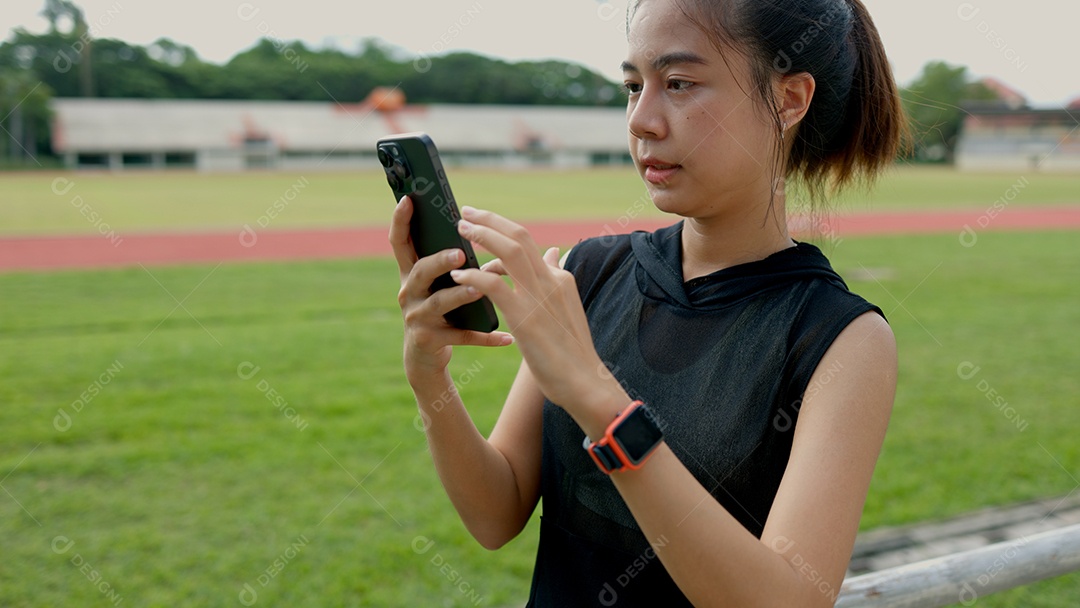 Uma mulher está olhando para o telefone em um campo gramado