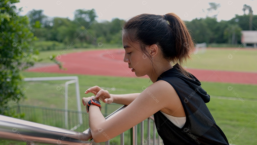 Jovem olhando no seu relógio o tempo de exercícios