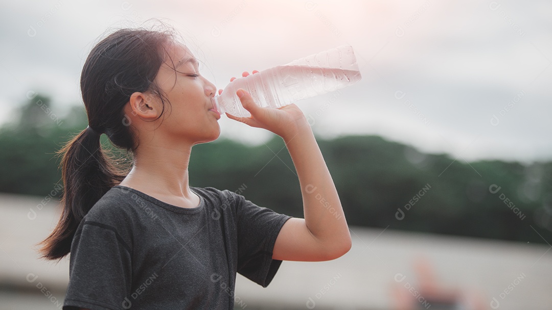 Uma garota bebendo água de uma garrafa