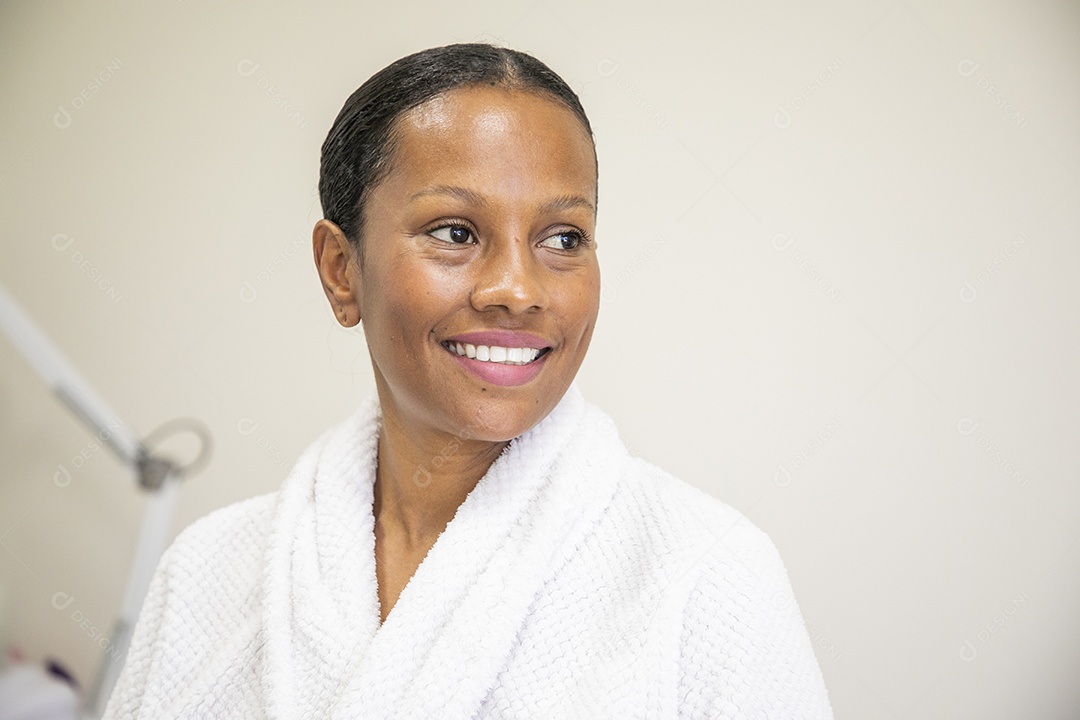 Mulher morena de roupão sorrindo