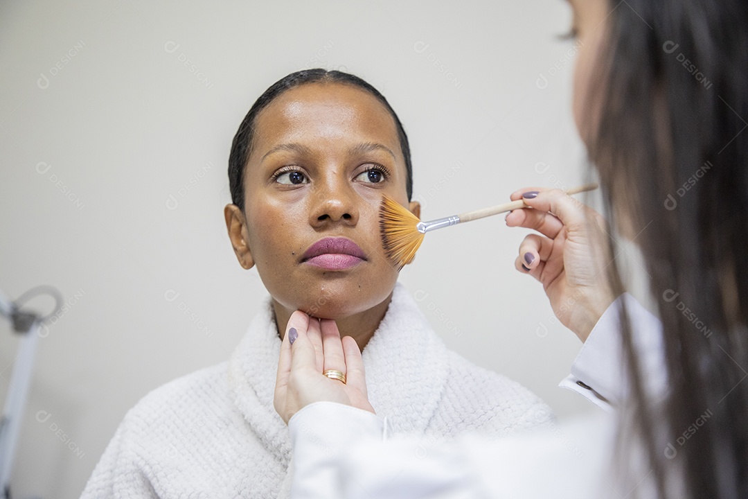Linda mulher sendo maquiada em estúdio