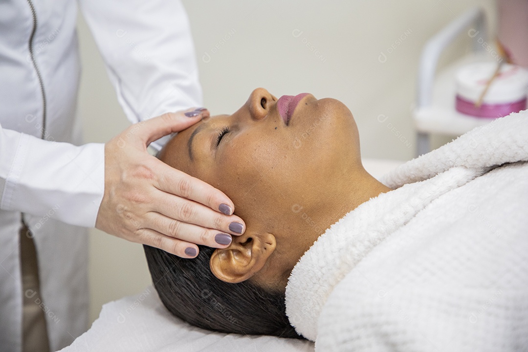 Mulher feliz usando roupão em procedimento facial