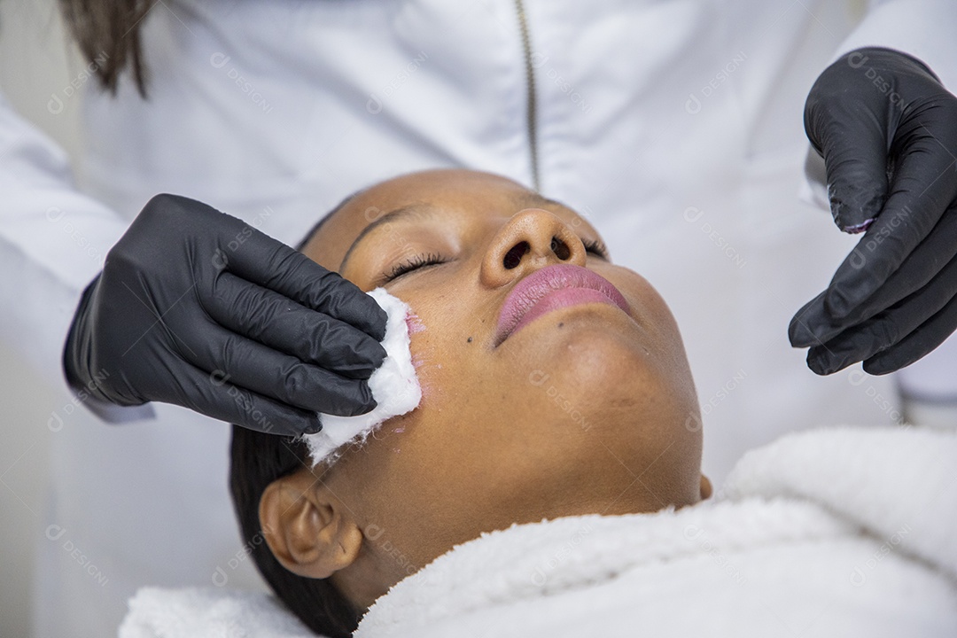 Esteticista aplicando e cuidando da pele de cliente
