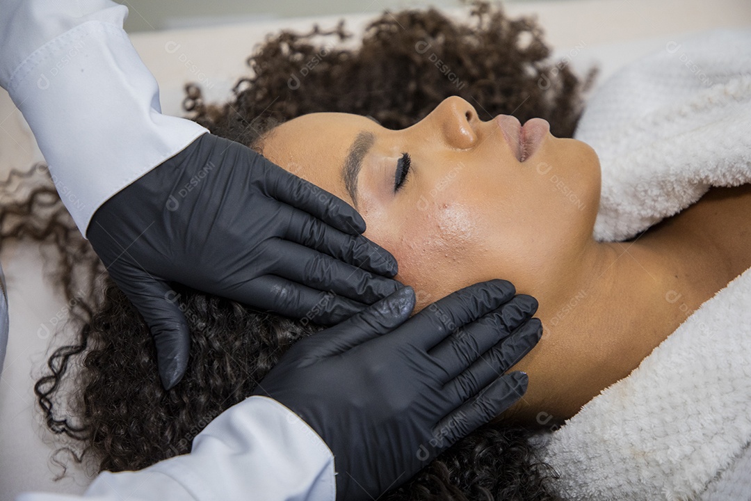 Jovem em estúdio estético usando protocolo de limpeza facial
