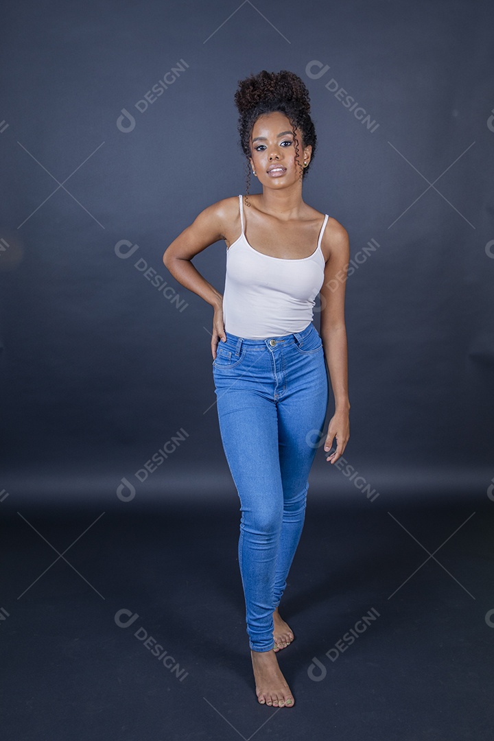 Jovem morena de cabelos cacheados fazendo pose para foto