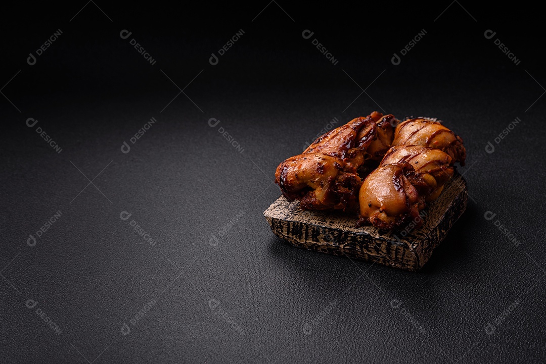 Delicioso frango assado ou espetinho de peru em um espeto com sal e especiarias em um fundo escuro de concreto