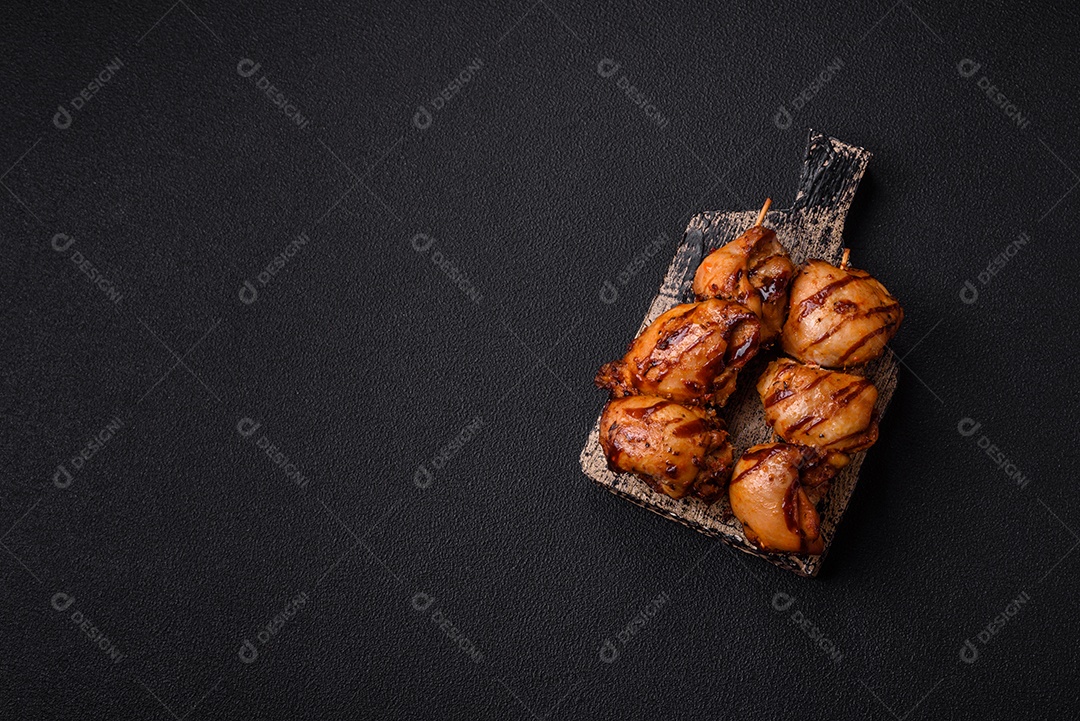 Delicioso frango assado ou espetinho de peru em um espeto com sal e especiarias em um fundo escuro de concreto