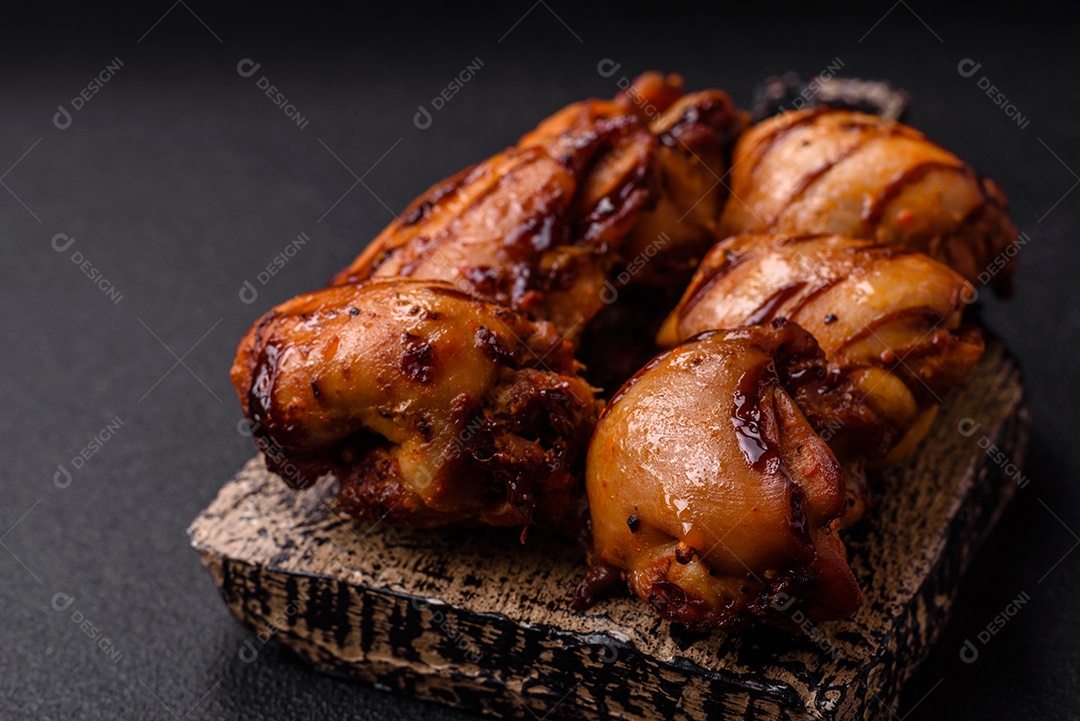 Delicioso frango assado ou espetinho de peru em um espeto com sal e especiarias em um fundo escuro de concreto