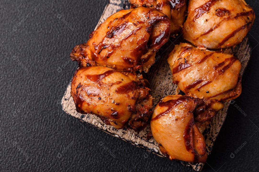 Delicioso frango assado ou espetinho de peru em um espeto com sal e especiarias em um fundo escuro de concreto