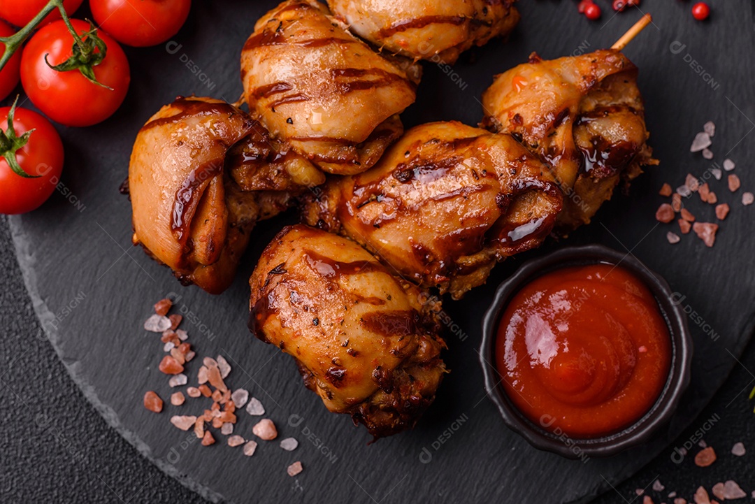 Delicioso frango assado ou espetinho de peru em um espeto com sal e especiarias em um fundo escuro de concreto