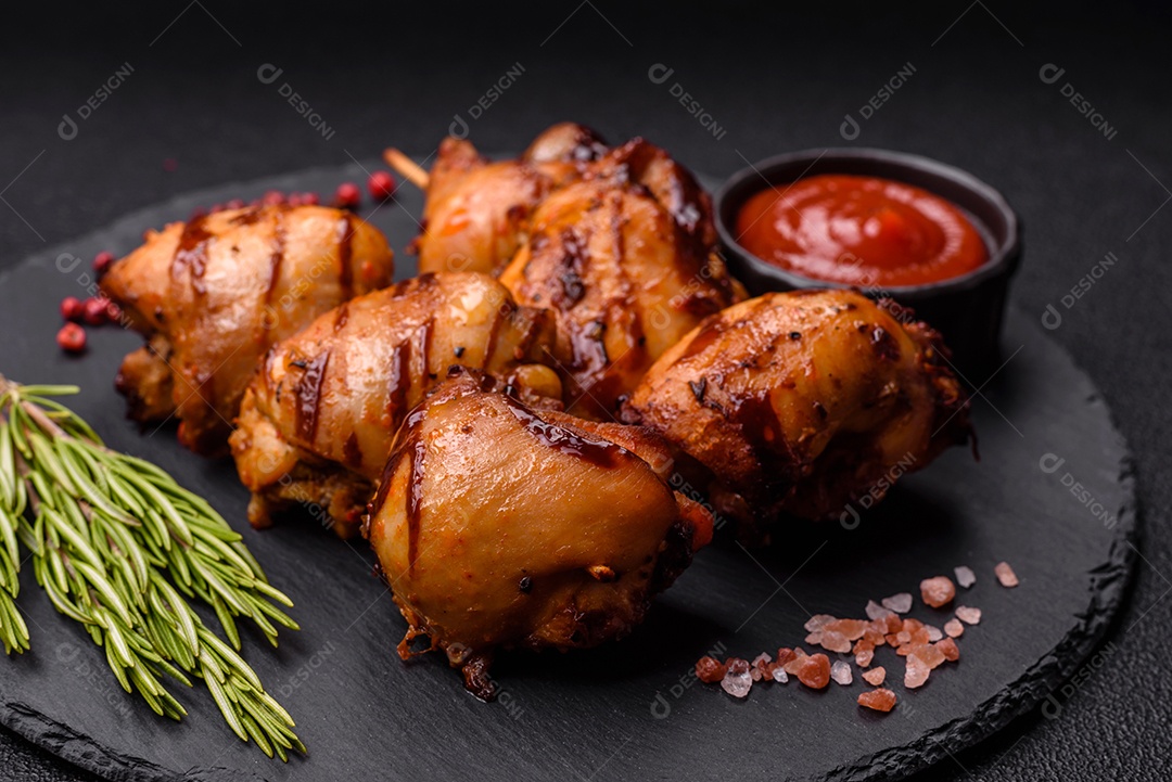 Delicioso frango assado ou espetinho de peru em um espeto com sal e especiarias em um fundo escuro de concreto