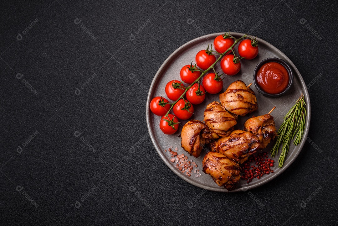 Delicioso frango assado ou espetinho de peru em um espeto com sal e especiarias em um fundo escuro de concreto