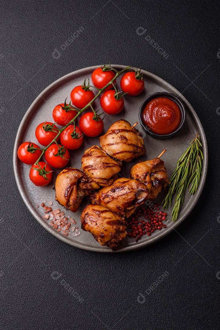Delicioso frango assado ou espetinho de peru em um espeto com sal e especiarias em um fundo escuro de concreto