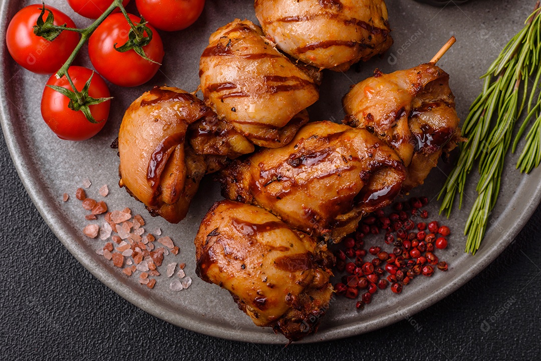 Delicioso frango assado ou espetinho de peru em um espeto com sal e especiarias em um fundo escuro de concreto