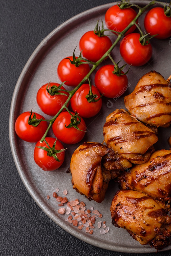 Delicioso frango assado ou espetinho de peru em um espeto com sal e especiarias em um fundo escuro de concreto