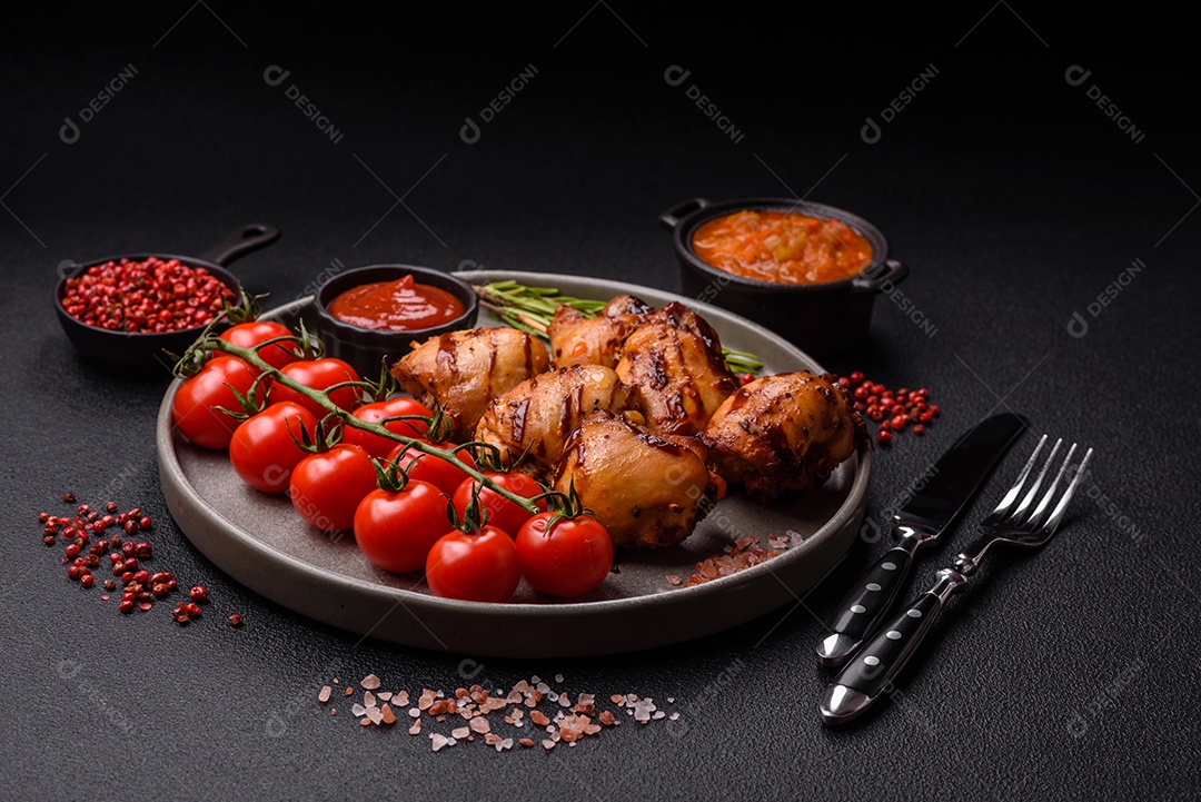 Delicioso frango assado ou espetinho de peru em um espeto com sal e especiarias em um fundo escuro de concreto