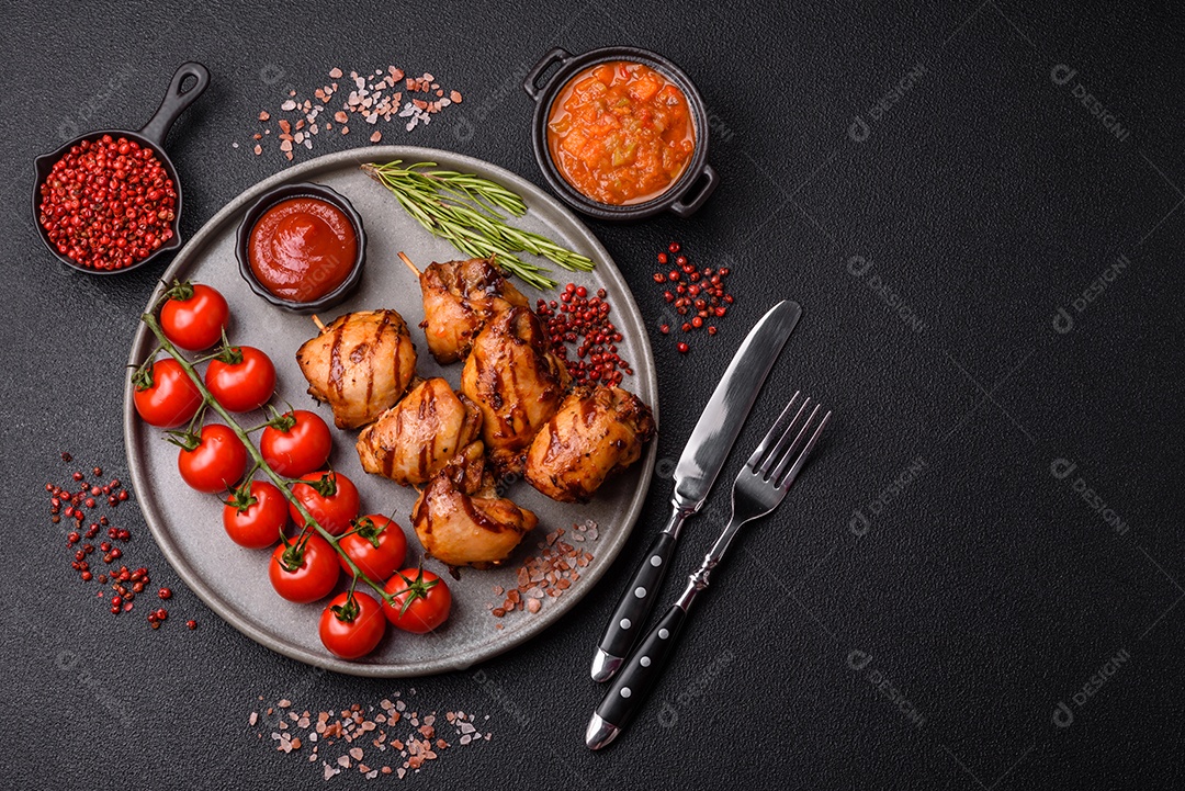 Delicioso frango assado ou espetinho de peru em um espeto com sal e especiarias em um fundo escuro de concreto