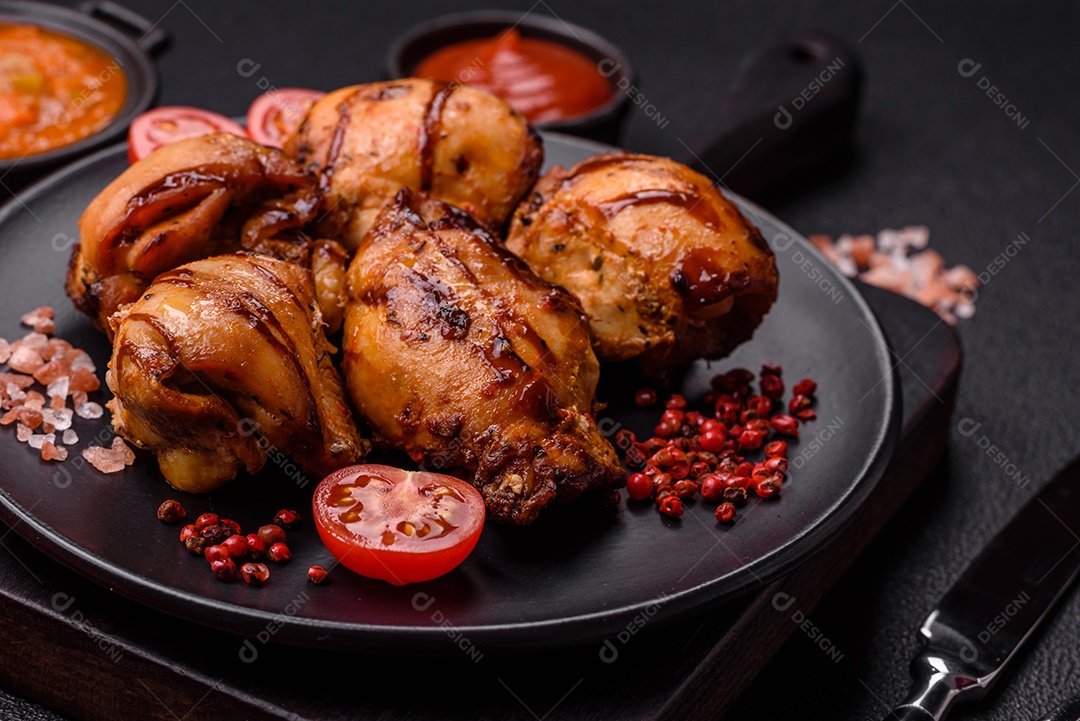 Delicioso frango assado ou espetinho de peru em um espeto com sal e especiarias em um fundo escuro de concreto