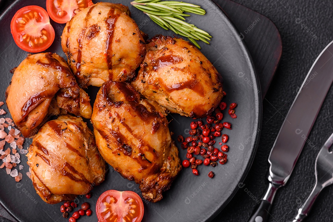 Delicioso frango assado ou espetinho de peru em um espeto com sal e especiarias em um fundo escuro de concreto