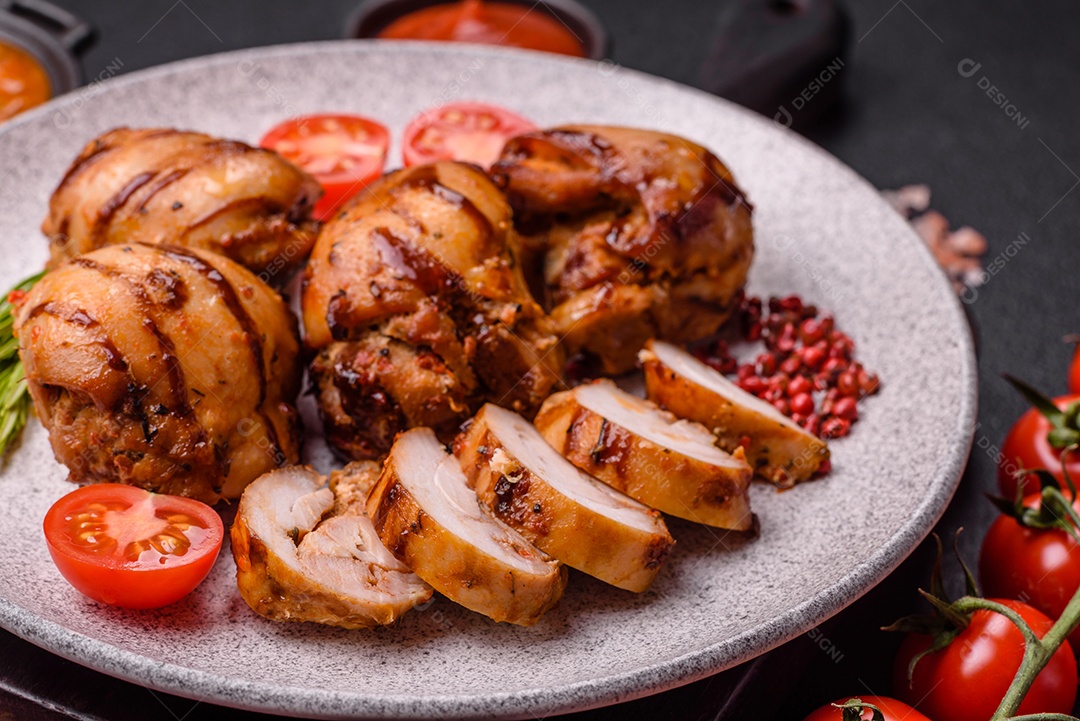 Delicioso frango assado ou espetinho de peru em um espeto com sal e especiarias em um fundo escuro de concreto