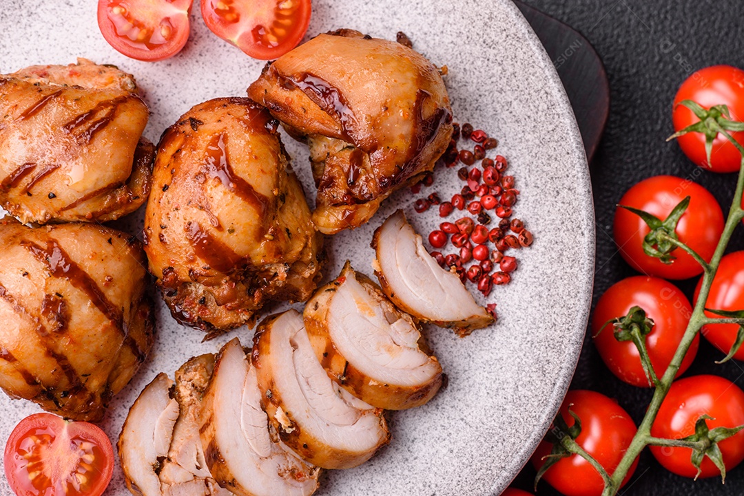 Delicioso frango assado ou espetinho de peru em um espeto com sal e especiarias em um fundo escuro de concreto