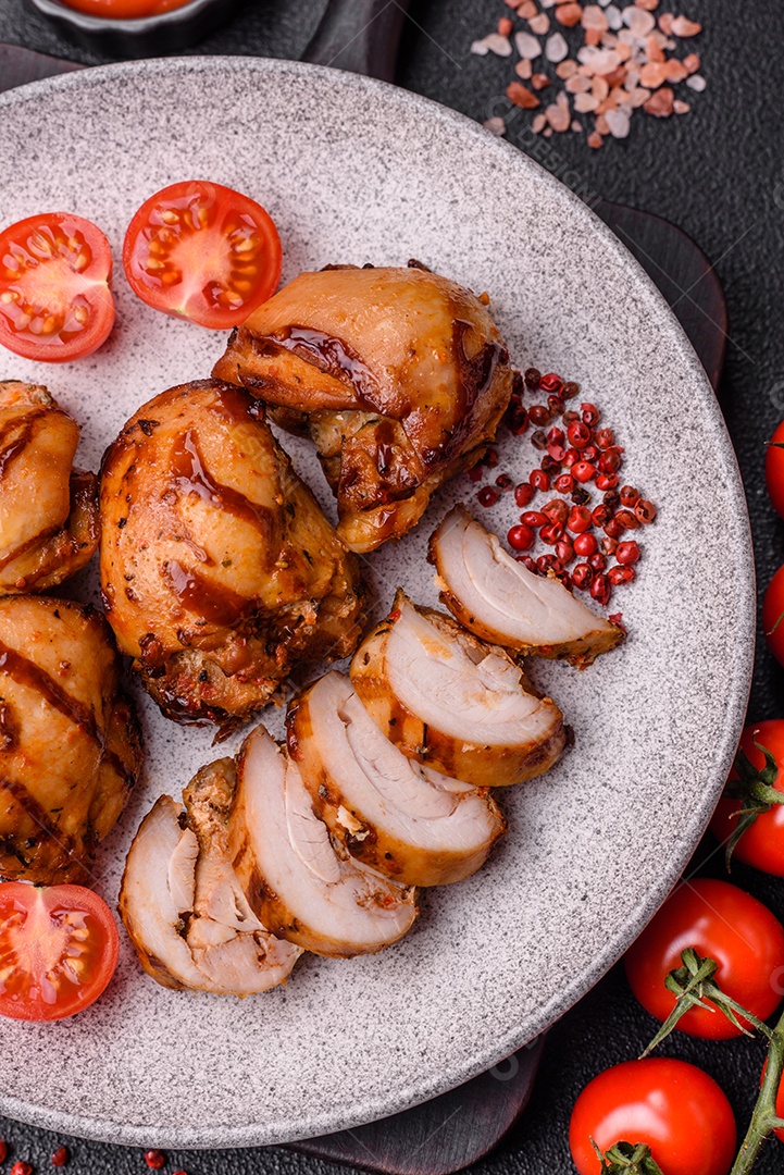 Delicioso frango assado ou espetinho de peru em um espeto com sal e especiarias em um fundo escuro de concreto