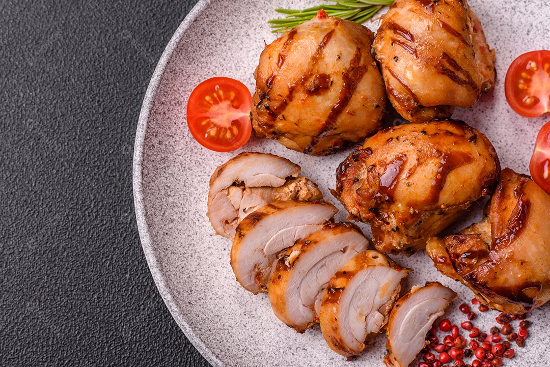 Delicioso frango assado ou espetinho de peru em um espeto com sal e especiarias em um fundo escuro de concreto