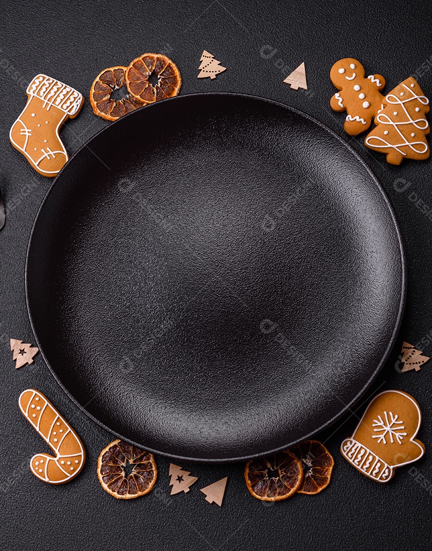 Linda composição festiva de Natal de um prato vazio, pães de gengibre e anis estrelado em um fundo escuro e texturizado