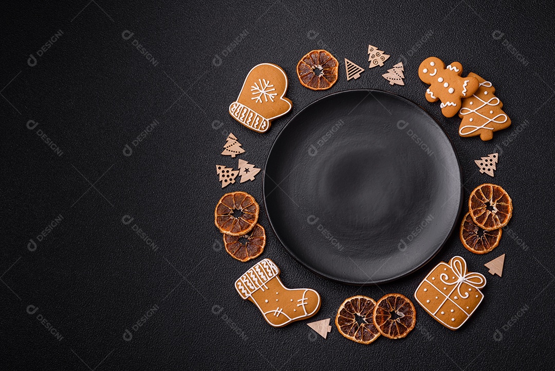 Linda composição festiva de Natal de um prato vazio, pães de gengibre e anis estrelado em um fundo escuro e texturizado