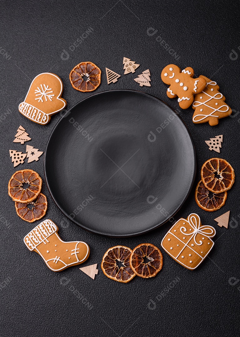 Linda composição festiva de Natal de um prato vazio, pães de gengibre e anis estrelado em um fundo escuro e texturizado