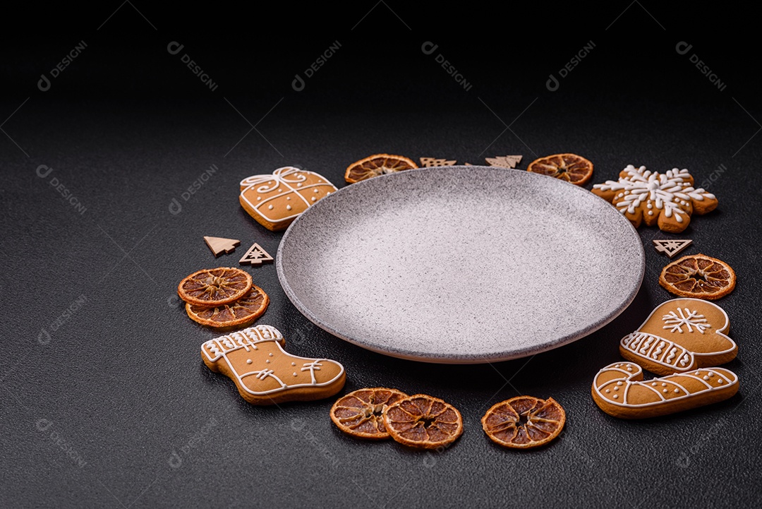 Linda composição festiva de Natal de um prato vazio, pães de gengibre e anis estrelado em um fundo escuro e texturizado