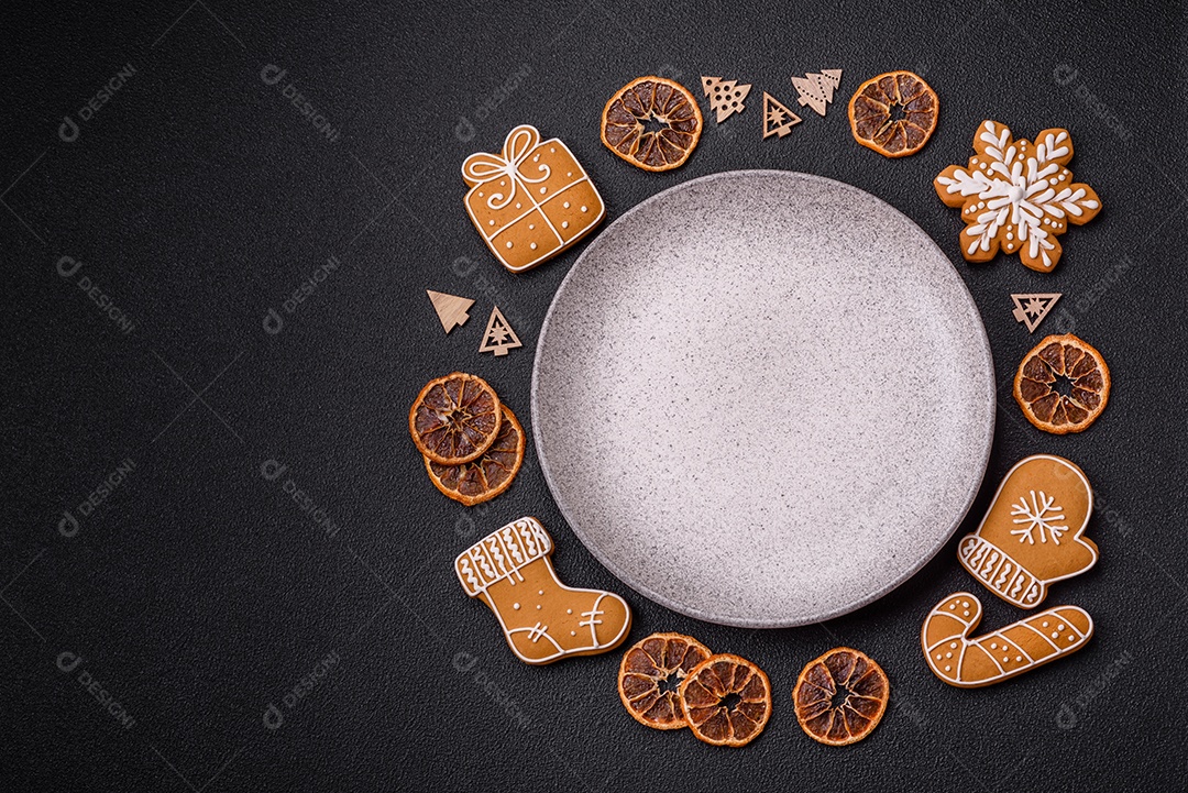 Linda composição festiva de Natal de um prato vazio, pães de gengibre e anis estrelado em um fundo escuro e texturizado