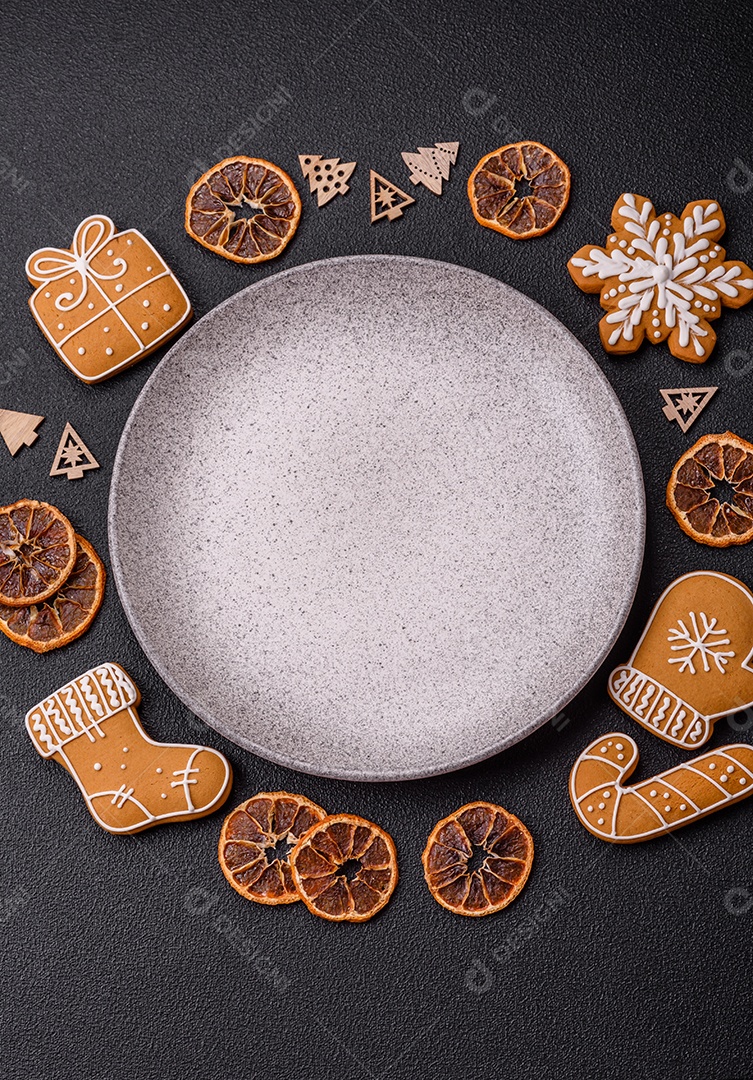 Linda composição festiva de Natal de um prato vazio, pães de gengibre e anis estrelado em um fundo escuro e texturizado