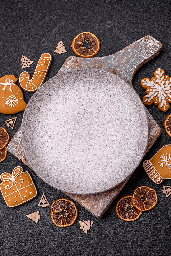 Linda composição festiva de Natal de um prato vazio, pães de gengibre e anis estrelado em um fundo escuro e texturizado