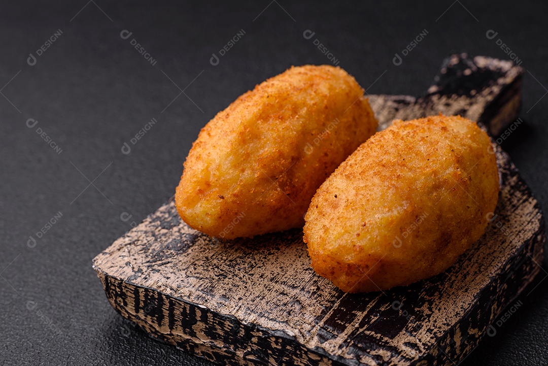 Delicioso frango Kiev ou costeletas de batata com sal, especiarias e ervas sobre um fundo escuro de concreto