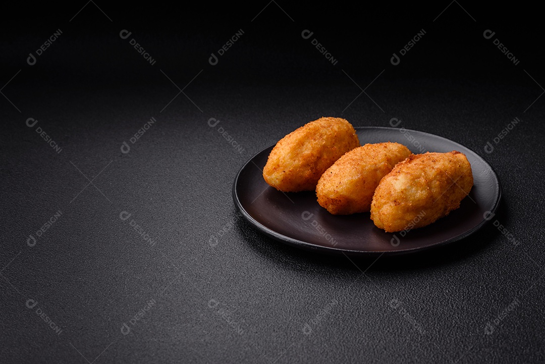 Delicioso frango Kiev ou costeletas de batata com sal, especiarias e ervas sobre um fundo escuro de concreto