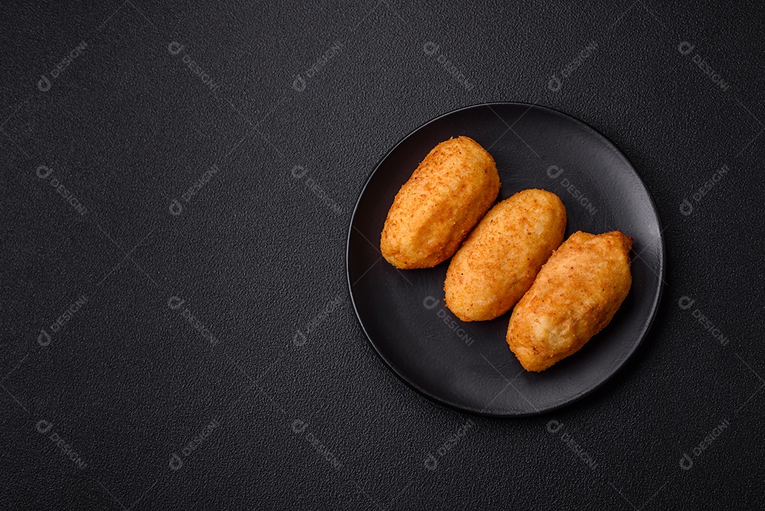 Delicioso frango Kiev ou costeletas de batata com sal, especiarias e ervas sobre um fundo escuro de concreto