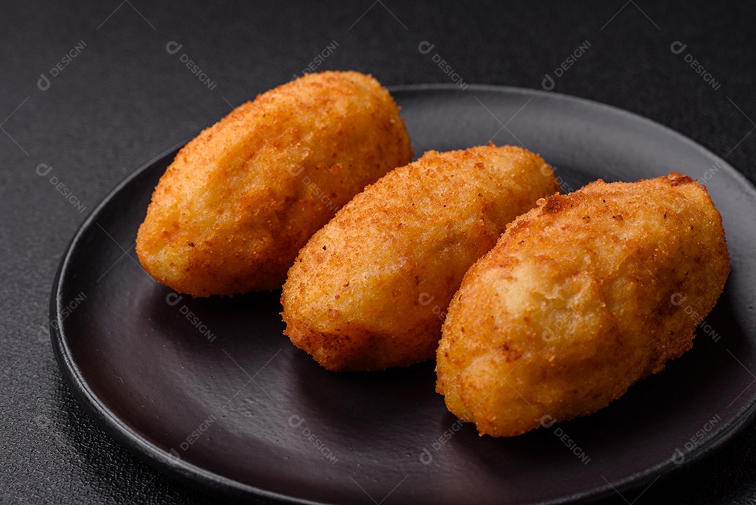 Delicioso frango Kiev ou costeletas de batata com sal, especiarias e ervas sobre um fundo escuro de concreto