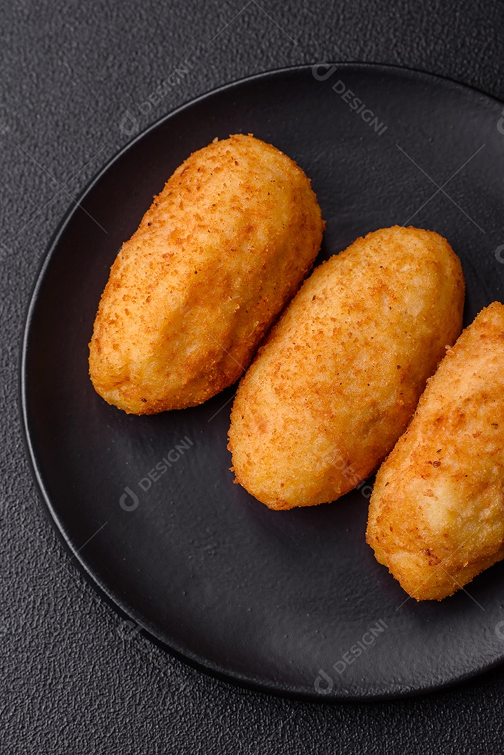 Delicioso frango Kiev ou costeletas de batata com sal, especiarias e ervas sobre um fundo escuro de concreto