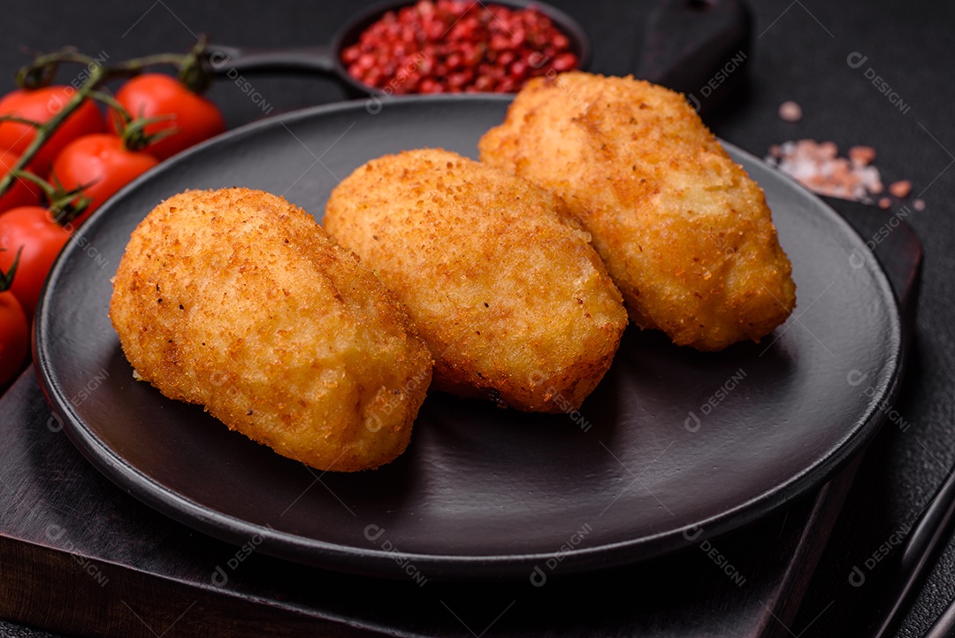 Delicioso frango Kiev ou costeletas de batata com sal, especiarias e ervas sobre um fundo escuro de concreto