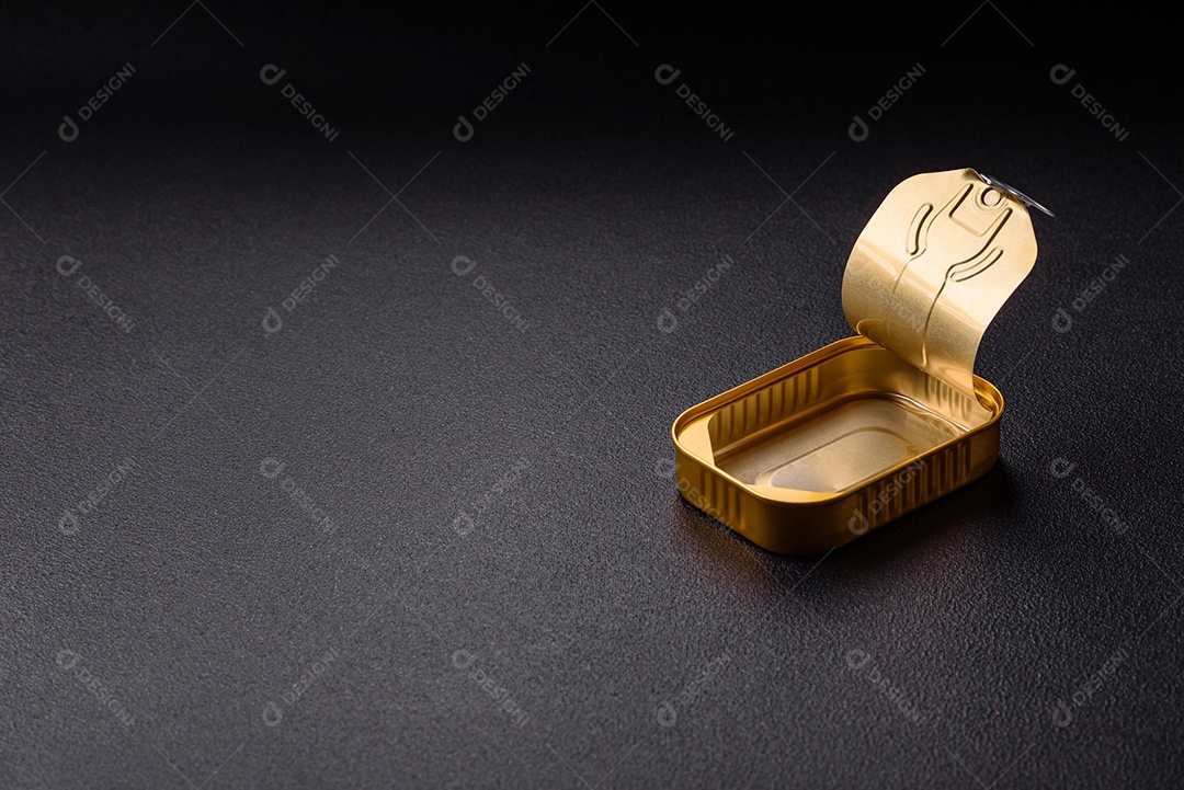 Lata metálica com carne ou peixe enlatado com chave para abri-lo sobre um fundo escuro de concreto