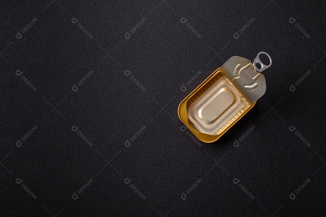 Lata metálica com carne ou peixe enlatado com chave para abri-lo sobre um fundo escuro de concreto