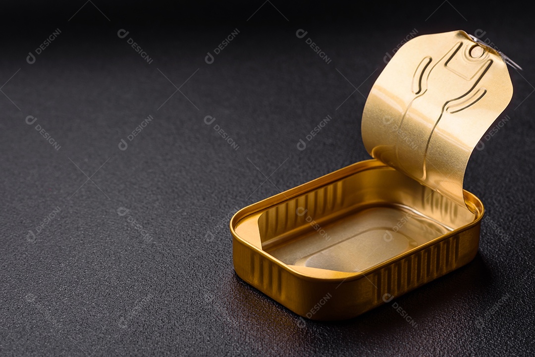 Lata metálica com carne ou peixe enlatado com chave para abri-lo sobre um fundo escuro de concreto